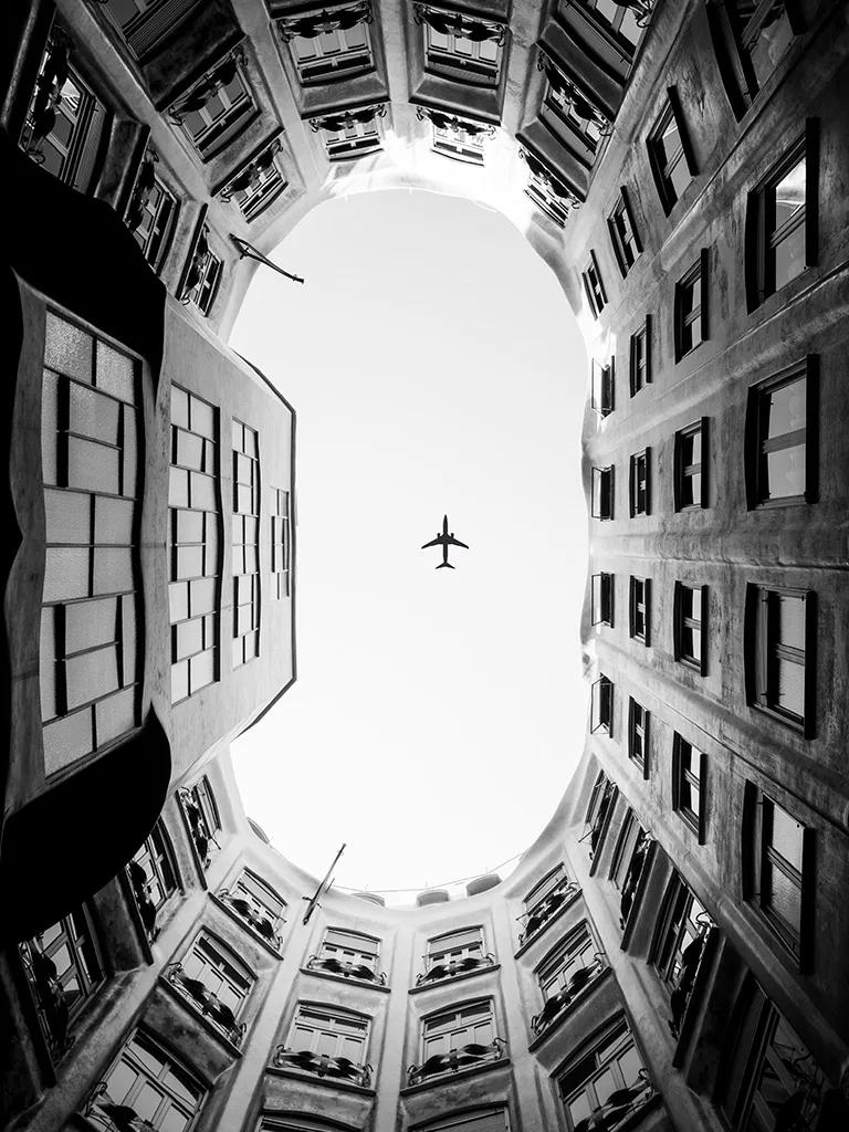 Un avion passe au dessus de la Casa Mila